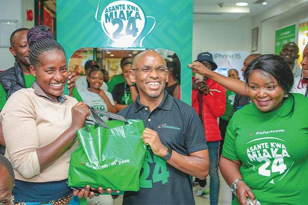 Safaricom PLC
CEO Peter Ndegwa
(center) presents
a gift hamper
to a customer
at the Junction
Mall shop during
the company’s
24th anniversary
celebration on
October 23, 2024.